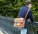 Tan leather satchel bike bag carried by a male model
