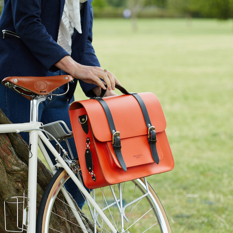 
            
                Load image into Gallery viewer, Orange leather satchel cycle bag attached to bicycle
            
        